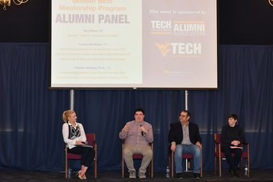 A panel of alumni on a stage
